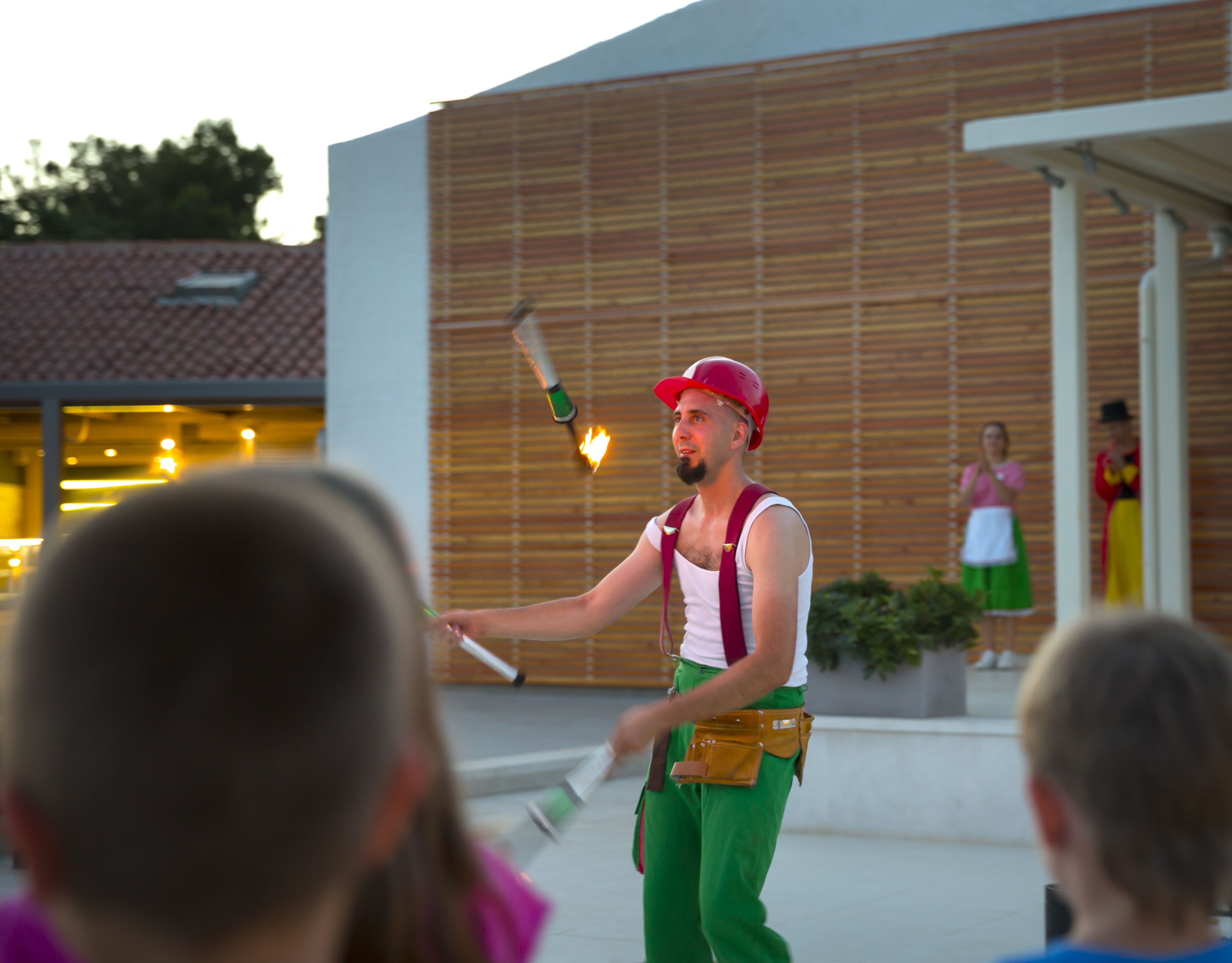 A person performing with a flaming torch in front of an audience.