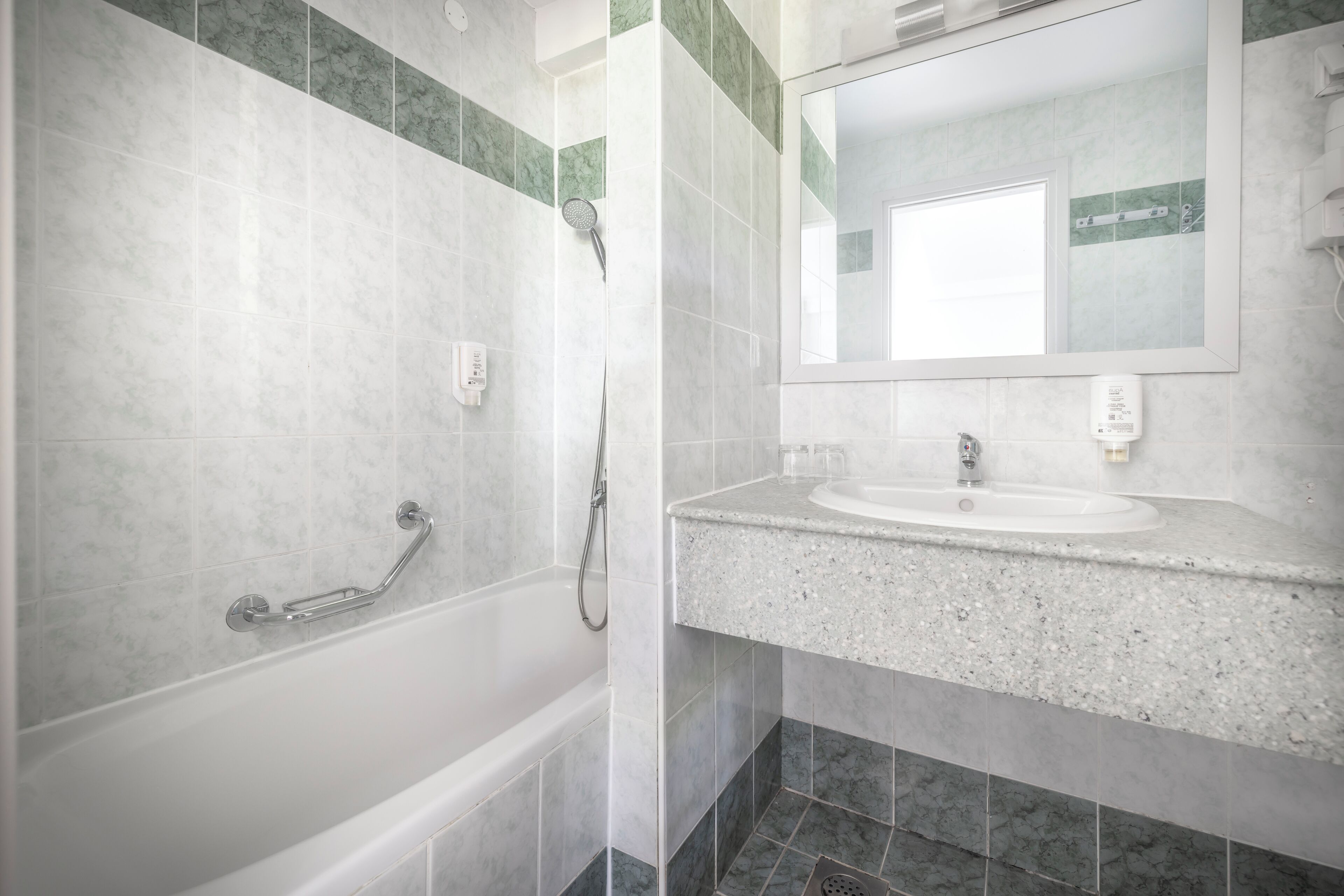 Ein Badezimmer mit Badewanne, Dusche, Waschbecken und Spiegel.