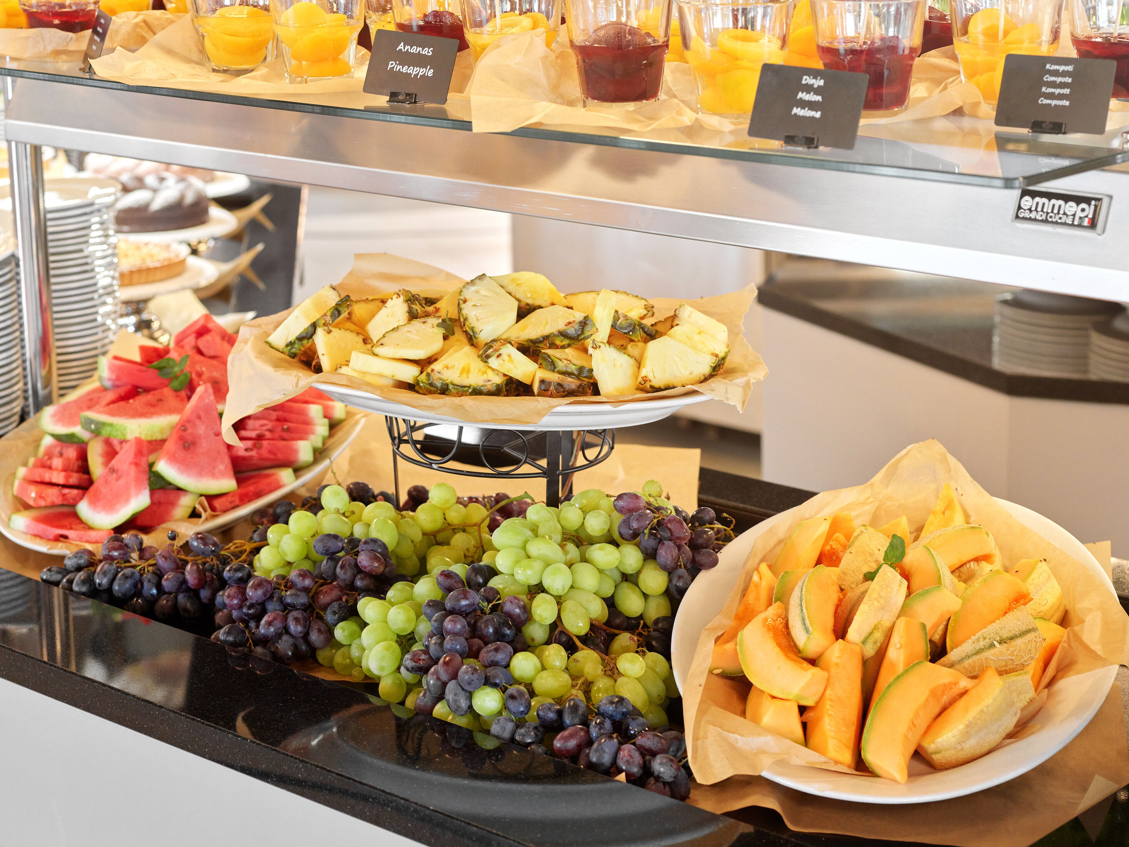 A buffet with various fruits and desserts.