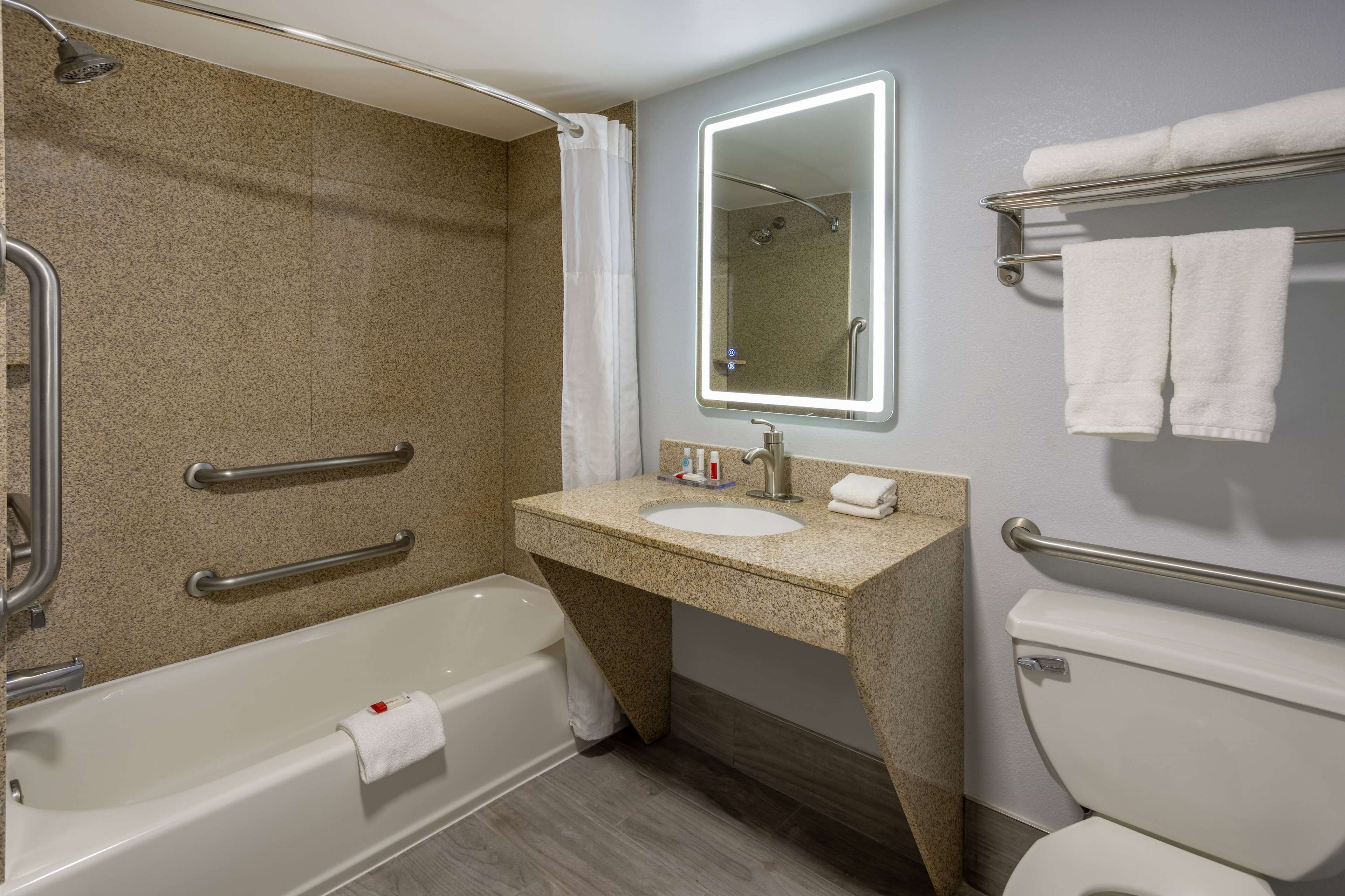 A modern bathroom with a bathtub, a sink, a toilet, and a shower.