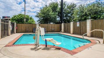 A swimming pool with a diving board and a no diving sign.