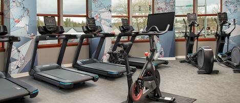 A gym with treadmills, ellipticals, and a stationary bike.