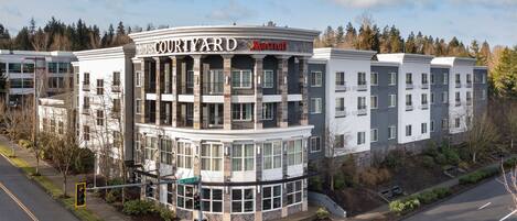 Ein Courtyard Marriott Hotel mit modernem Design, das mehrere Balkone und große Fenster bietet.