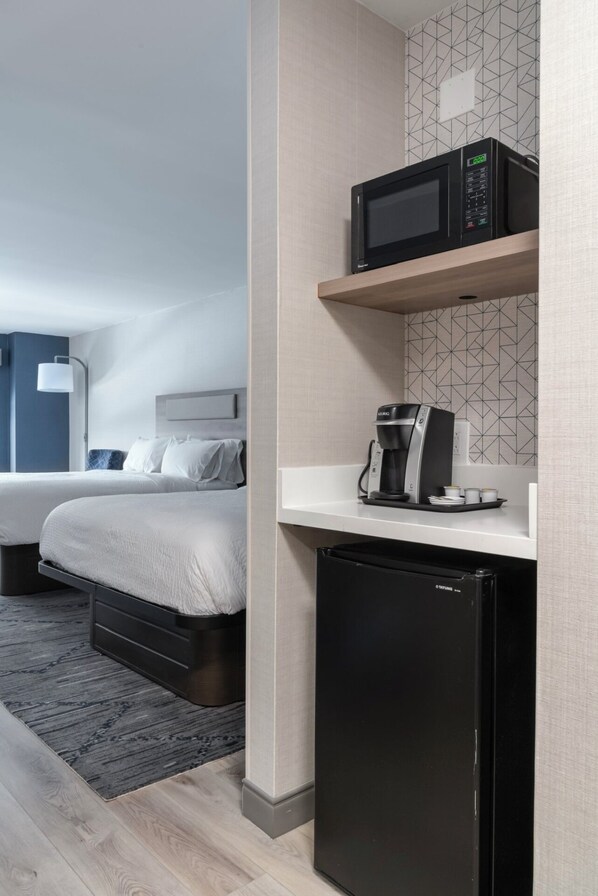A hotel room with a bed, a small kitchenette with a microwave, coffee maker, and refrigerator. - Holiday Inn Express Hotel & Suites Drums by IHG (Drums)
