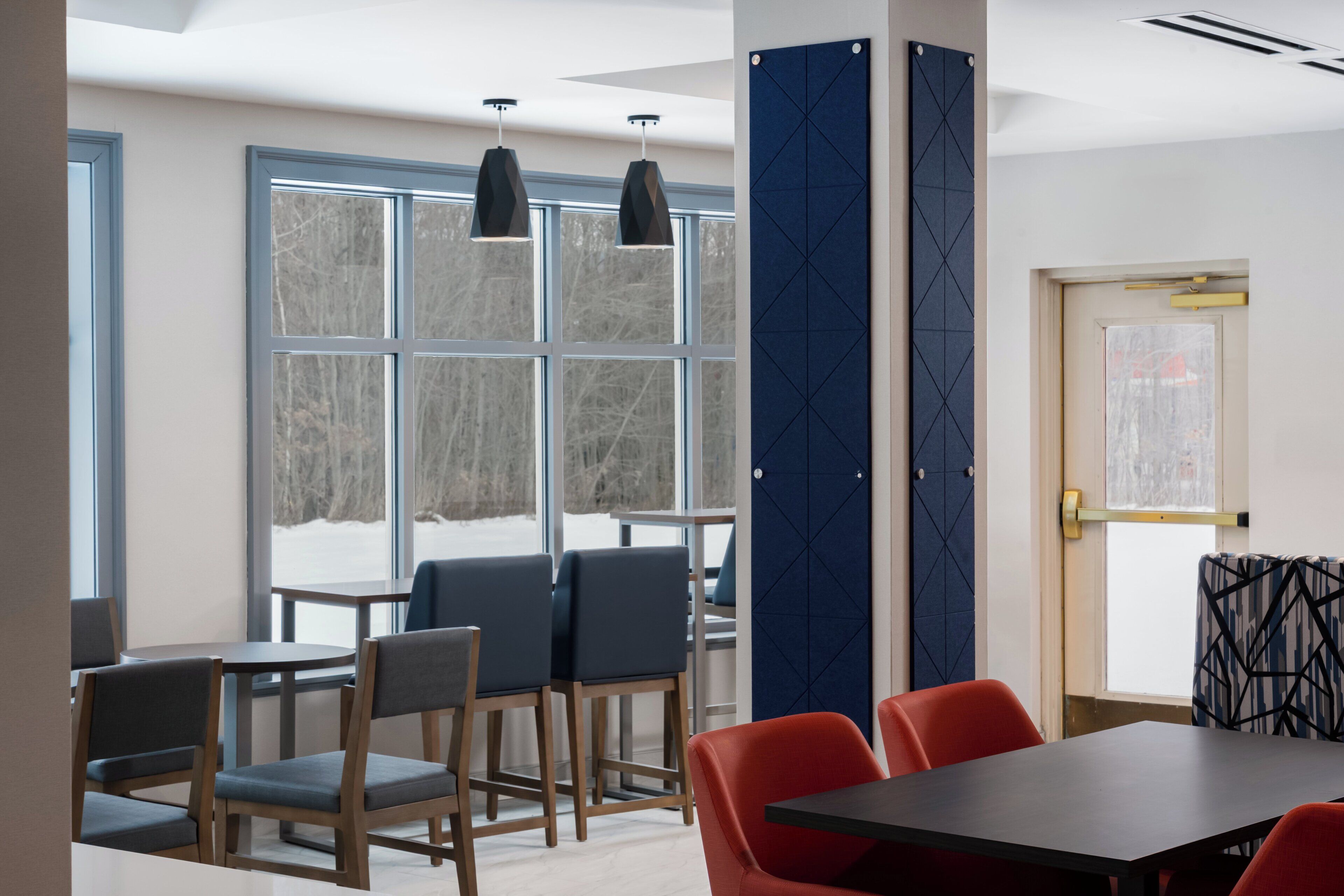 A conference room with a large table, several chairs, and pendant lighting.