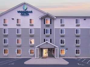 A multi-story hotel with a flat facade, a prominent sign at the top, and a central entrance with a covered walkway.