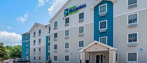 A StayAmerica hotel with a modern design, featuring a flat roof and multiple windows.