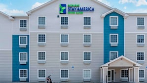 A multi-story hotel with a sign for Extended Stay America Select Suites. - Extended Stay America Select Suites - Pensacola - Northeast (Pensacola)