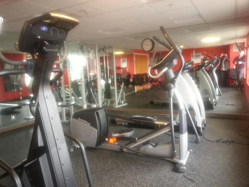 A gym with stationary bikes, mirrors, and exercise equipment.