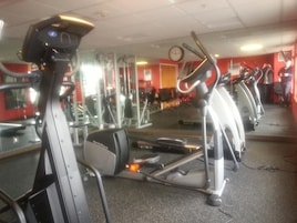 Un gimnasio con bicicletas estáticas, espejos y equipo de ejercicio.