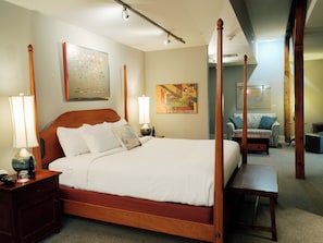 Relax in a stylish room with a four-poster bed, nightstand, and seating area.