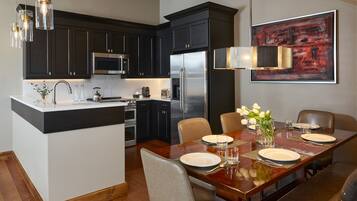 A modern kitchen with dark cabinetry, stainless steel appliances, and a central island.