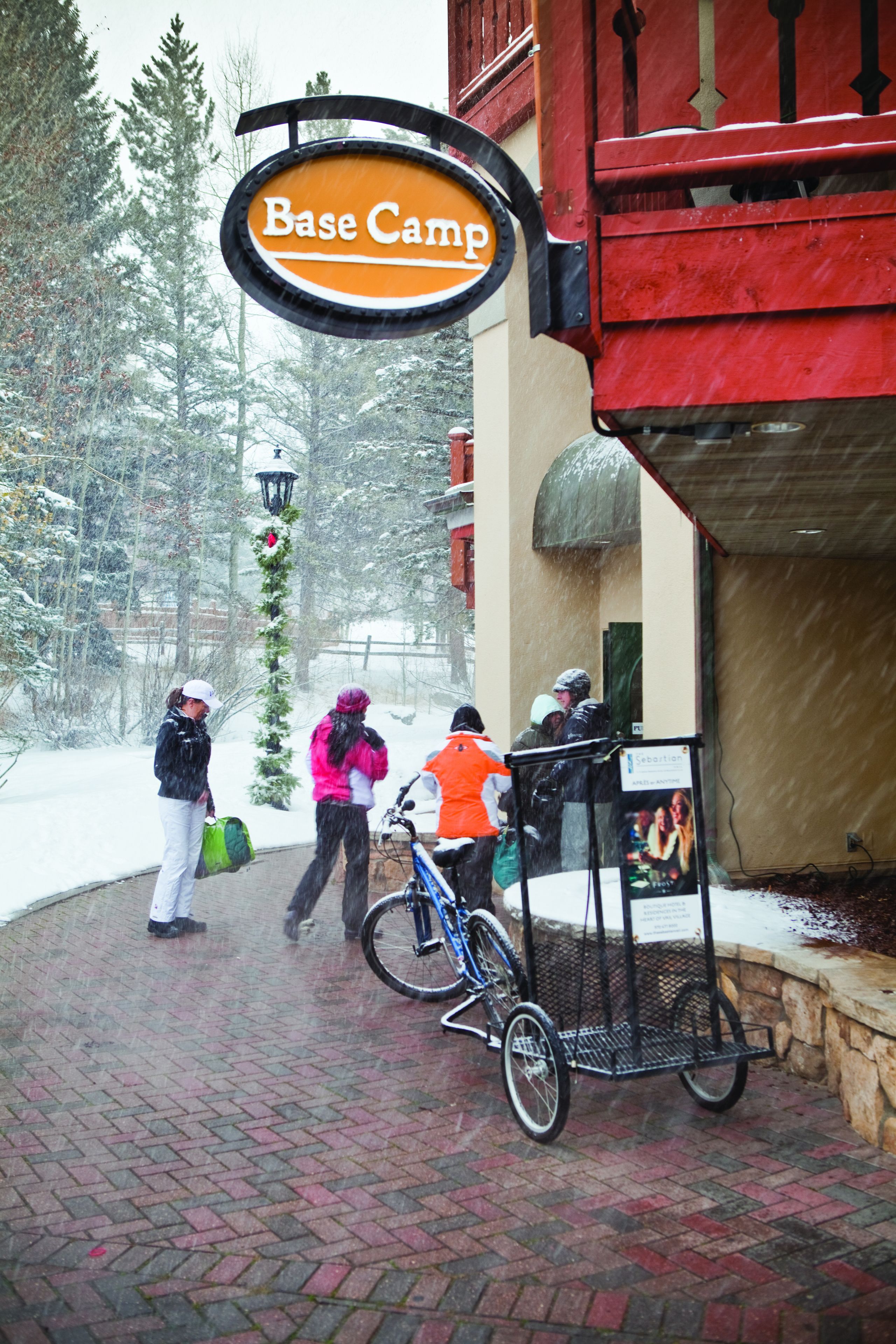 A sign for Base Camp, a brick pathway, and a bicycle with a basket.