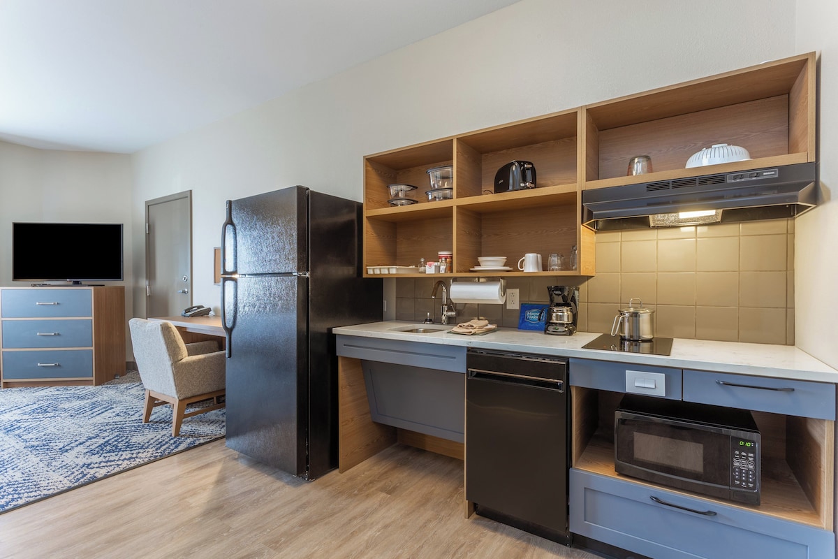 A compact kitchen with a refrigerator, microwave, and coffee maker.