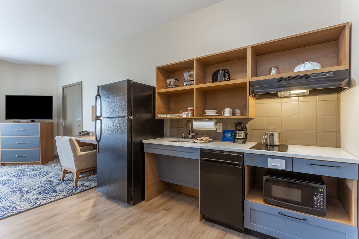 A compact kitchen with a refrigerator, microwave, and coffee maker.