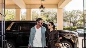 A man and woman walking out of a building with a black SUV parked outside. - Hotel Granduca Houston (Houston)
