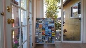 A glass door with a poster board displaying various travel brochures. - Hitching Post Studios Inn (Santa Cruz)