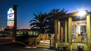 A hotel entrance with a sign for 'Hitching Post Studios Inn' indicating availability and amenities like daily kitchen studios and free Wi-Fi. - Hitching Post Studios Inn (Santa Cruz)