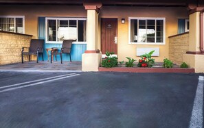A building with a porch, a door, and a window.