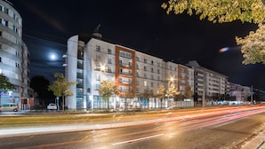 A multi-story hotel with a modern design, featuring balconies and large windows.