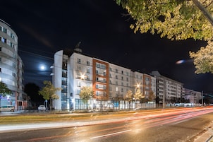 Un hotel de varios pisos con un diseño moderno, con balcones y ventanas amplias.