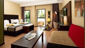A hotel room with a bed, a desk, a chair, a sofa, and a TV. - Holiday Inn Turin Corso Francia by IHG (Turin)