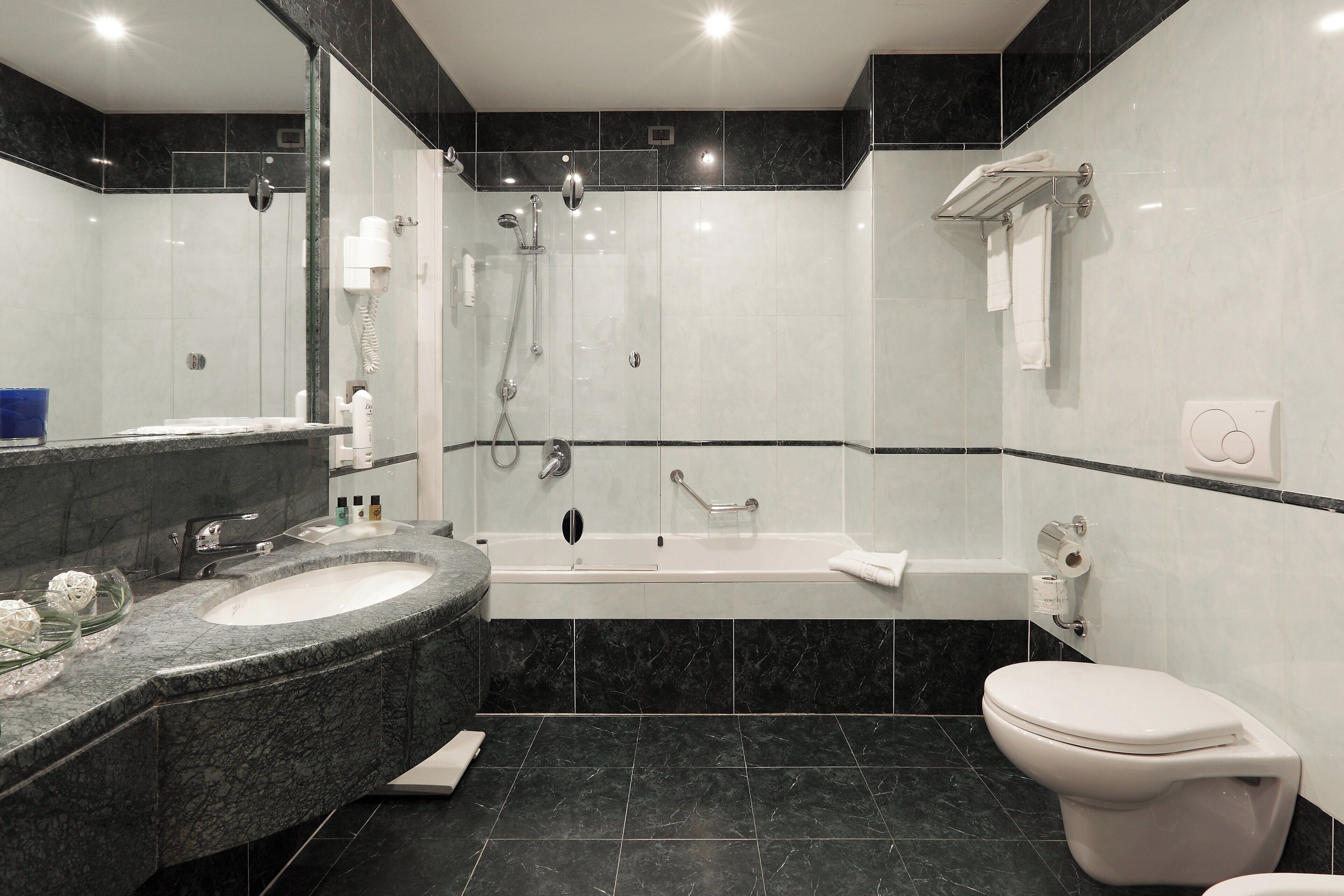 Ein modernes Badezimmer mit einem großen Waschbecken, einer Badewanne und einer Toilette.