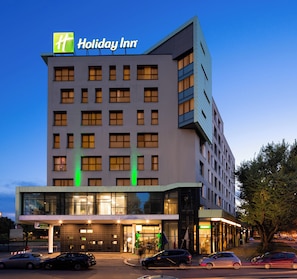 A Holiday Inn hotel with a modern design, featuring multiple floors and a prominent entrance.