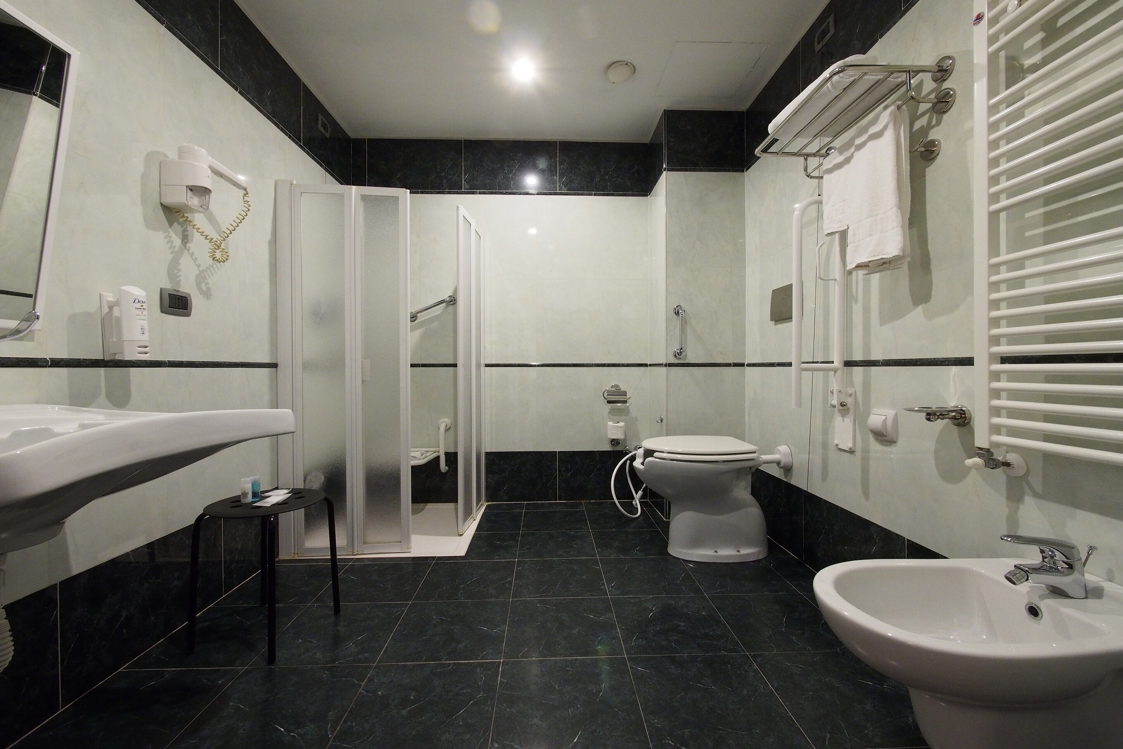 A modern bathroom with a large sink, bidet, toilet, and bidet shower.
