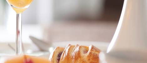 A breakfast setting with a croissant and a glass of orange juice.