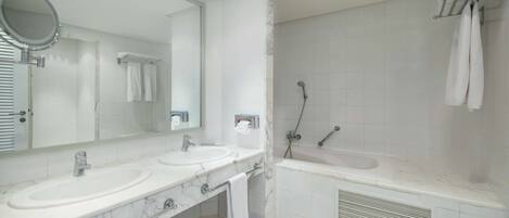 A bathroom with two sinks, a large mirror, a shower, and a bathtub.