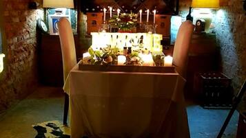 A dimly lit room with a table set for two, candles, and a 'WELCOME' sign.