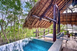 An infinity pool with a wooden deck and a thatched roof structure. - Morgan’s Rock Reserve & Lodge (San Juan del Sur)