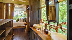 Un intérieur en bois avec un lit, deux éviers et une grande fenêtre.