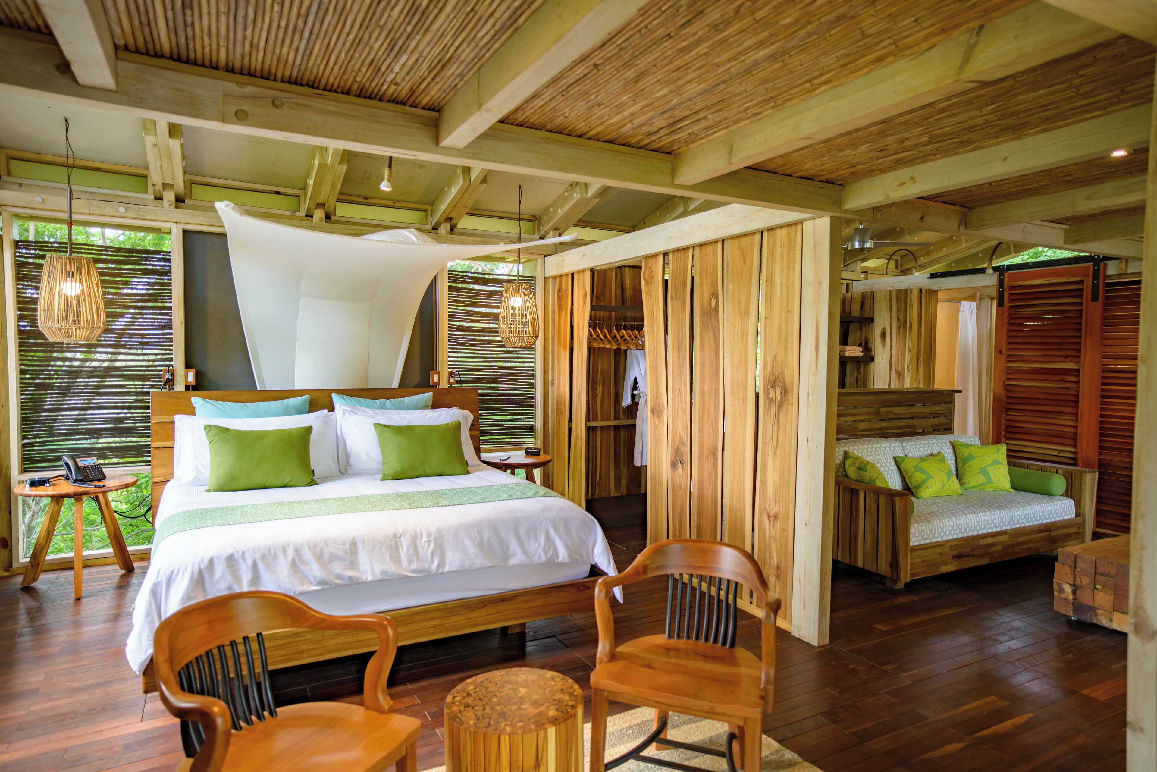 Een ruime slaapkamer met een groot bed, houten meubels en uitzicht op het omliggende landschap.