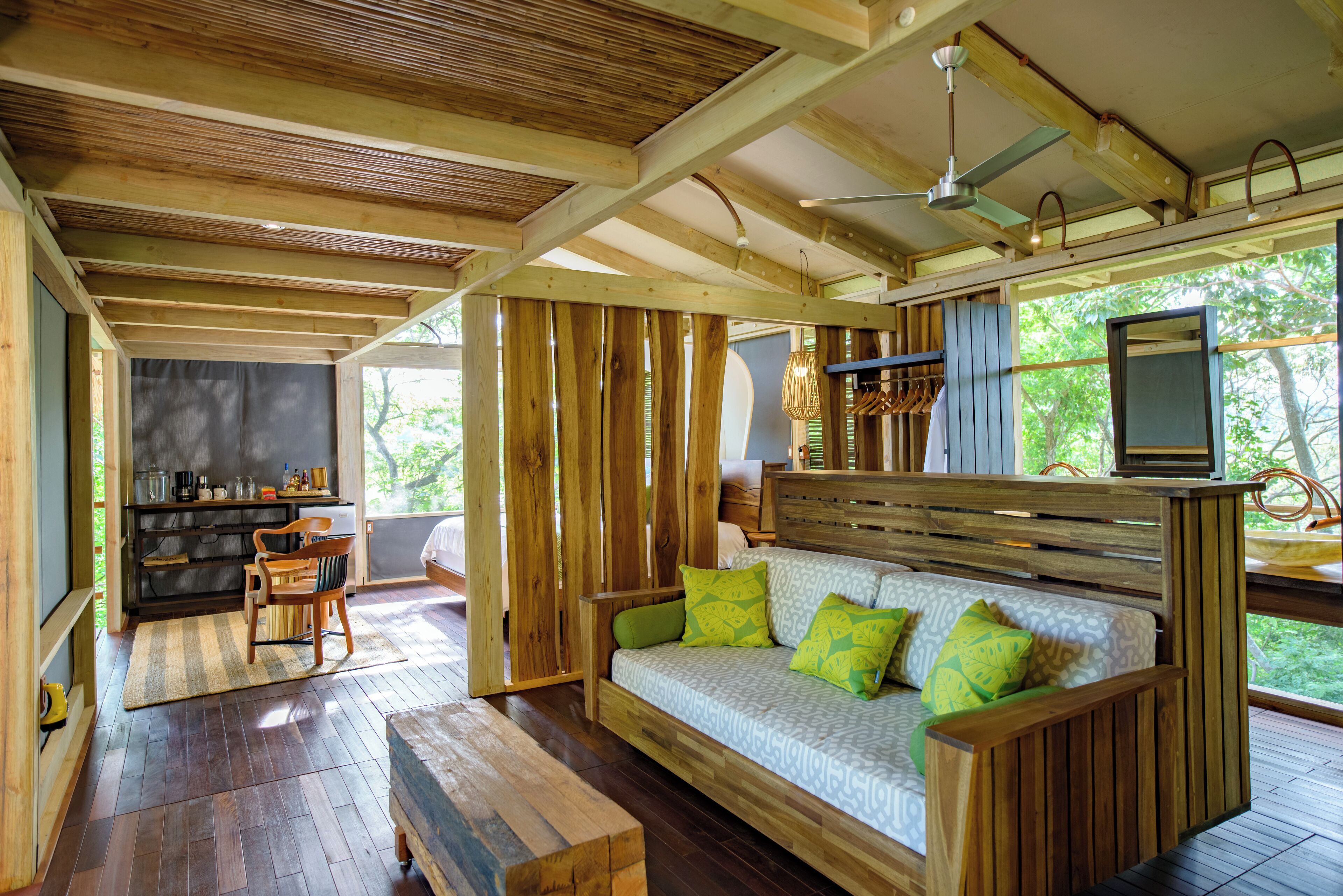 A wooden interior with a sofa, a chair, a television, and a bookshelf.