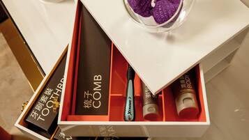 A white box with a purple orchid, containing a toothbrush and two tubes labeled 'COMB' and 'VANISH'.