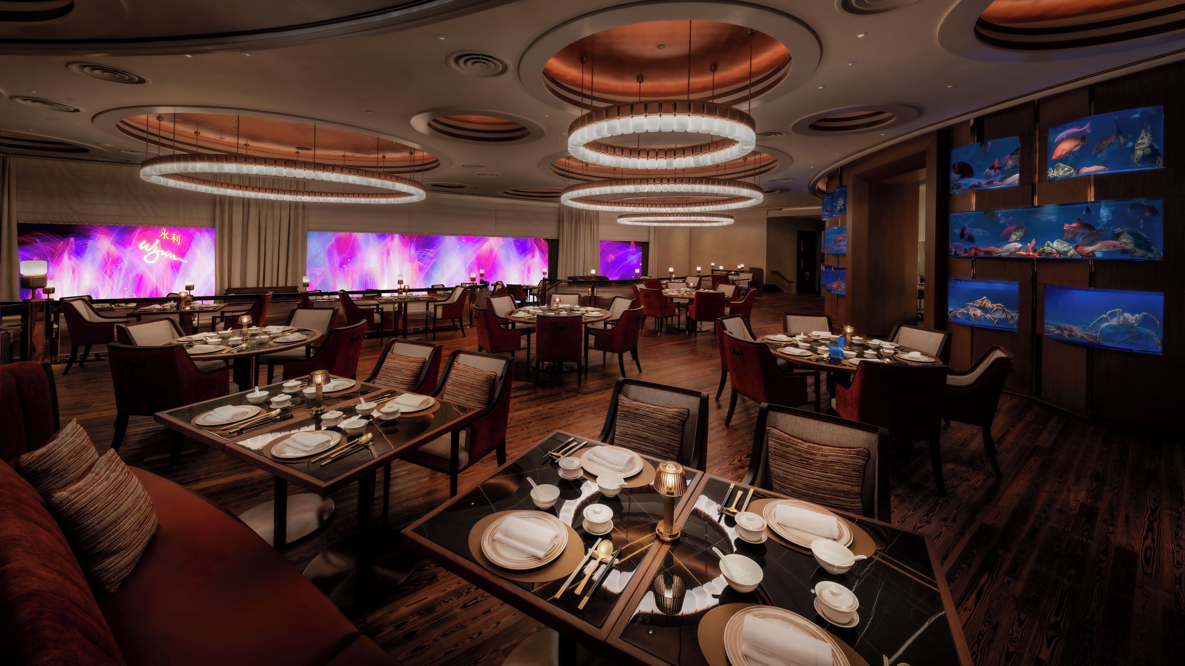 A restaurant with multiple dining areas, round tables, and chairs.