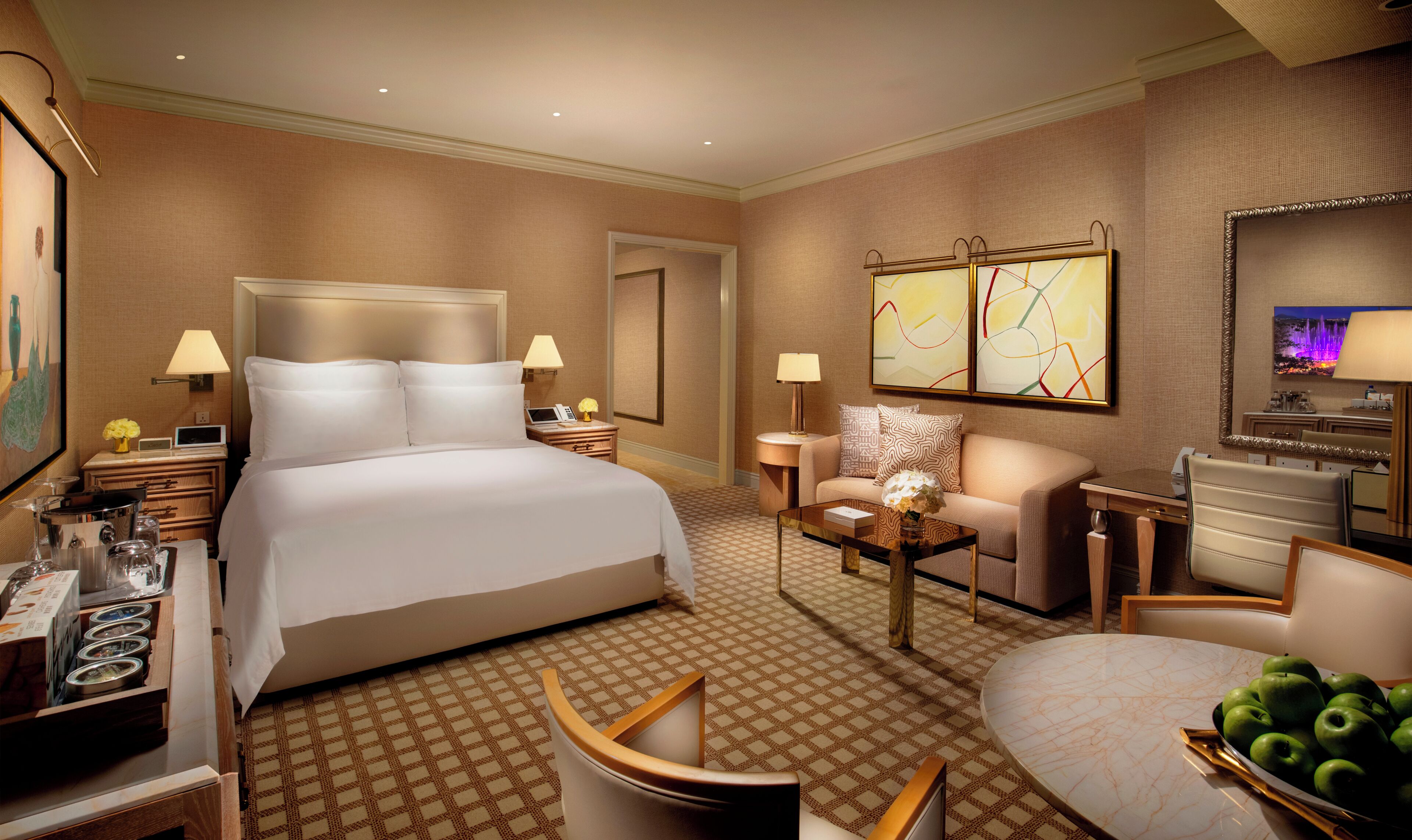 Una habitación de hotel con una cama grande, un sofá, un escritorio y una mesa de comedor.