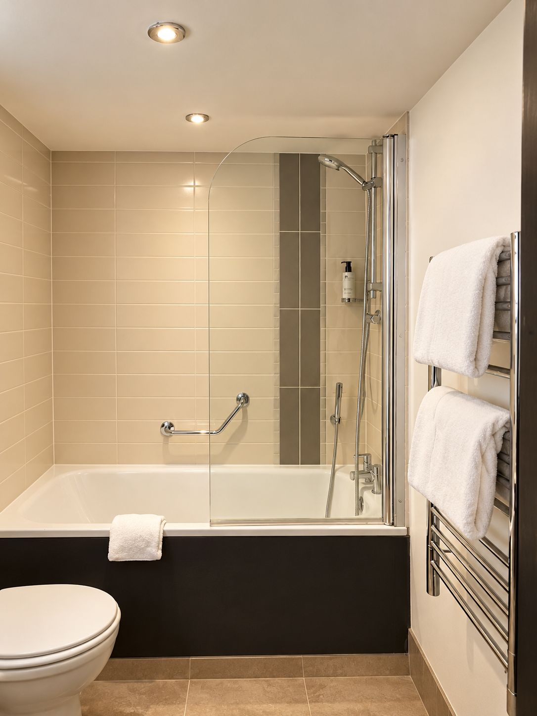 Un bagno moderno con doccia vetrata, vasca da bagno e WC.