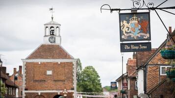 A historic building with a clock tower and a sign for "The Kings Arms" pub.