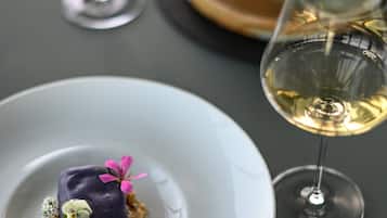 Uma mesa de jantar com pratos de comida, copos de vinho e talheres.