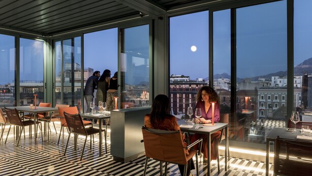 Un restaurante con piso a cuadros, ventanas amplias y vista a la ciudad.
