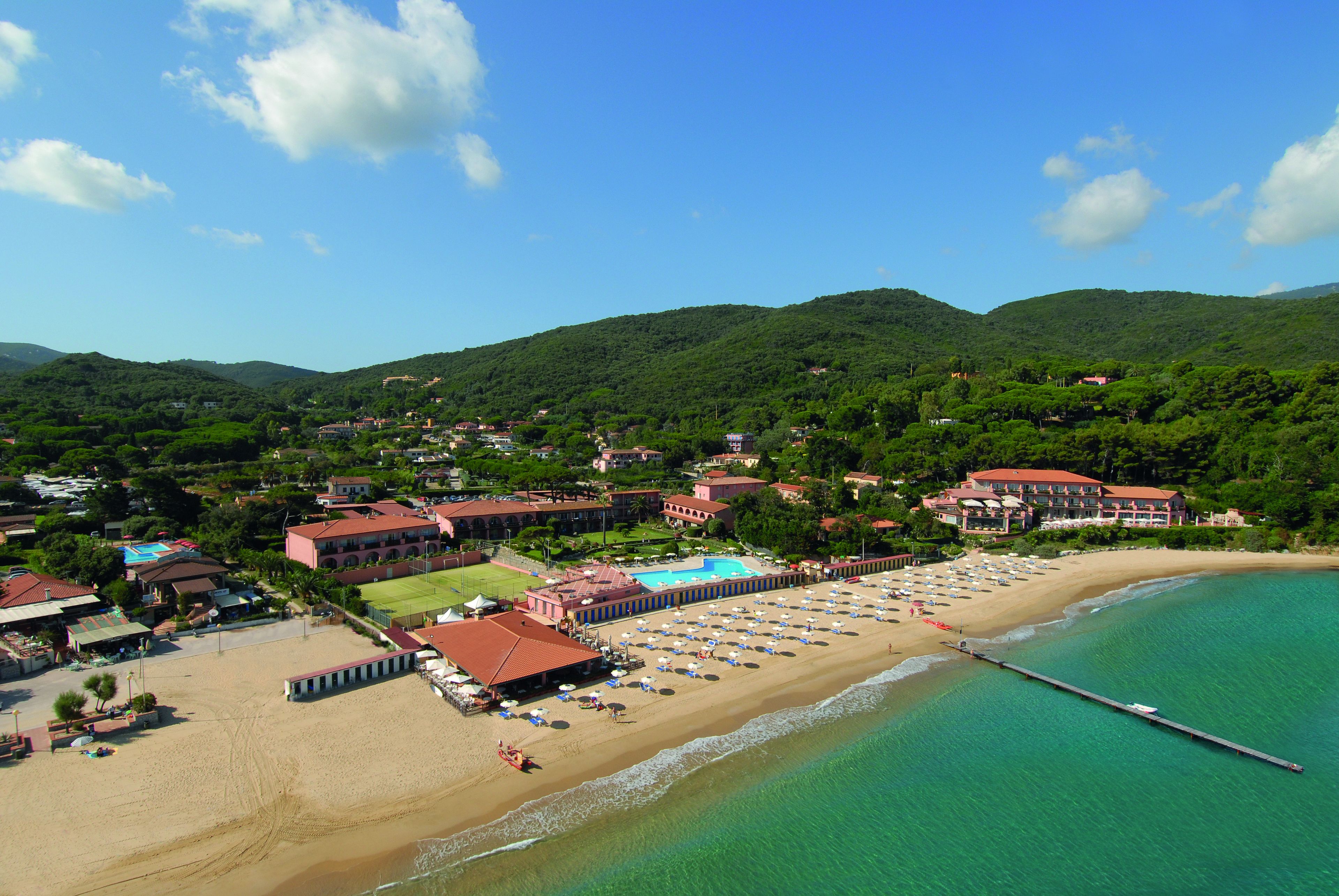 A coastal resort with a beach, a pool, and a pier.