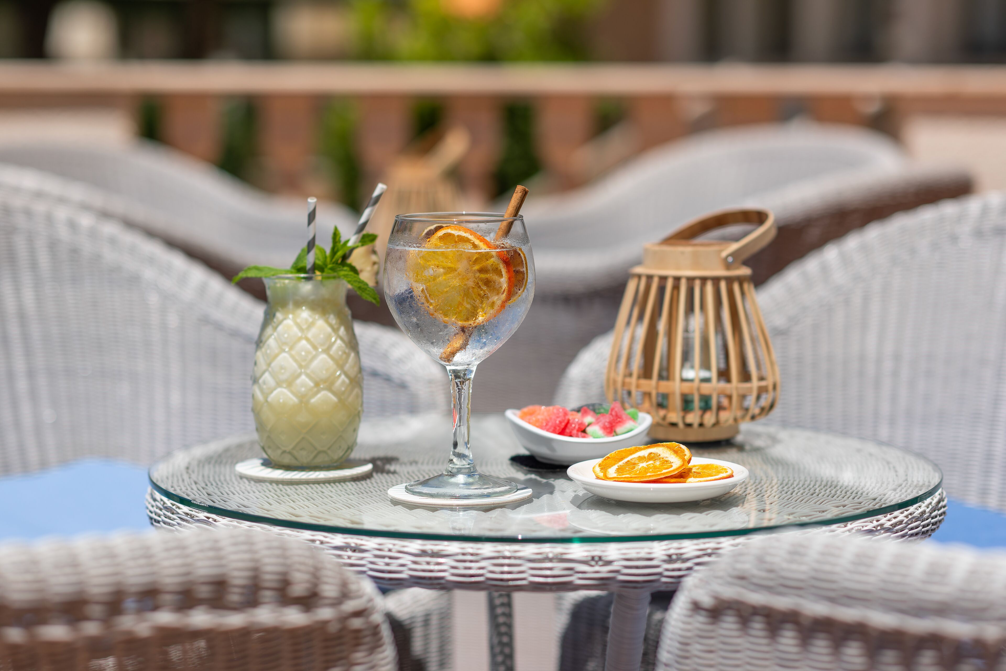 Une table en verre avec une boisson, une carafe et une assiette de nourriture.