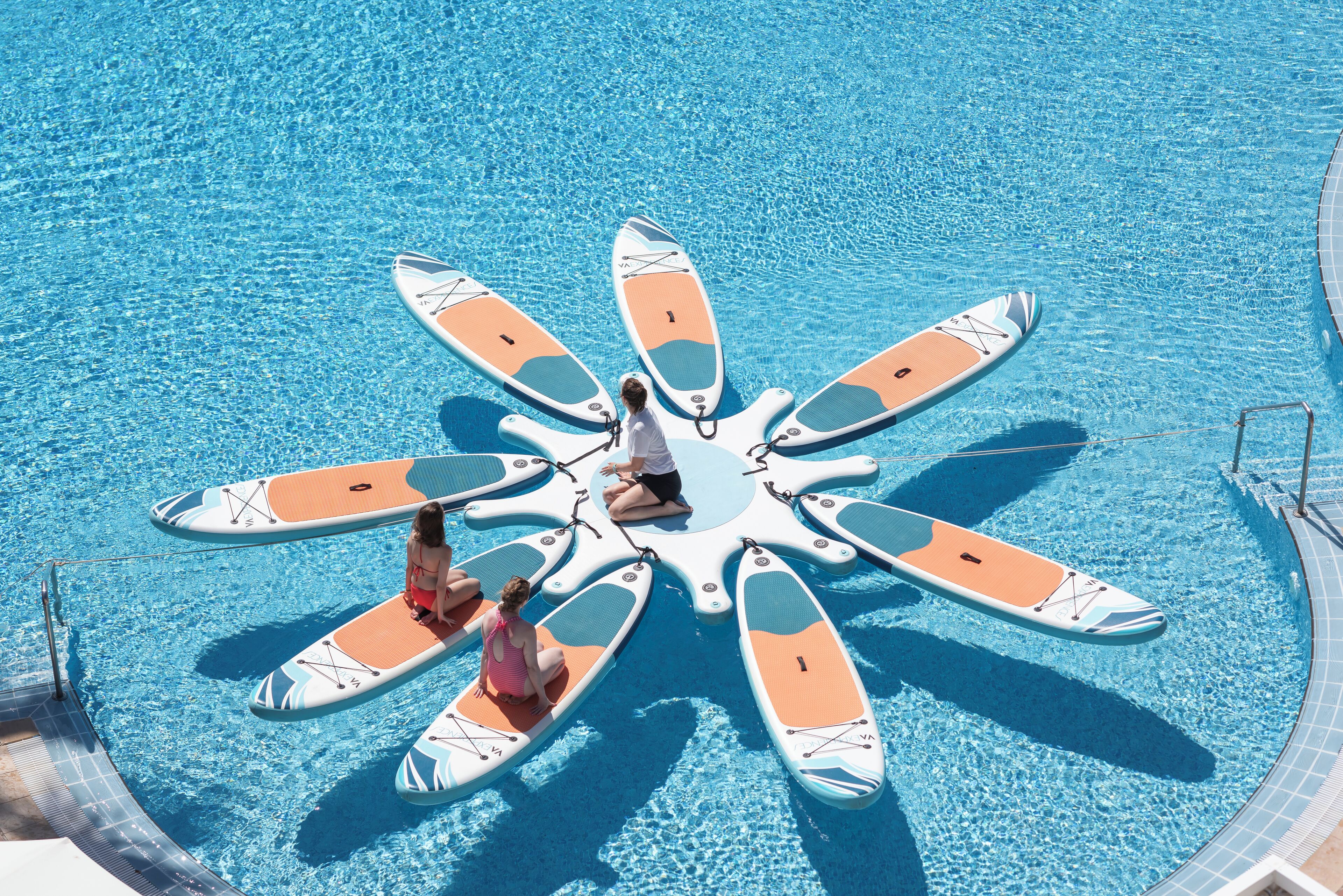 A circular arrangement of paddleboards in a swimming pool.