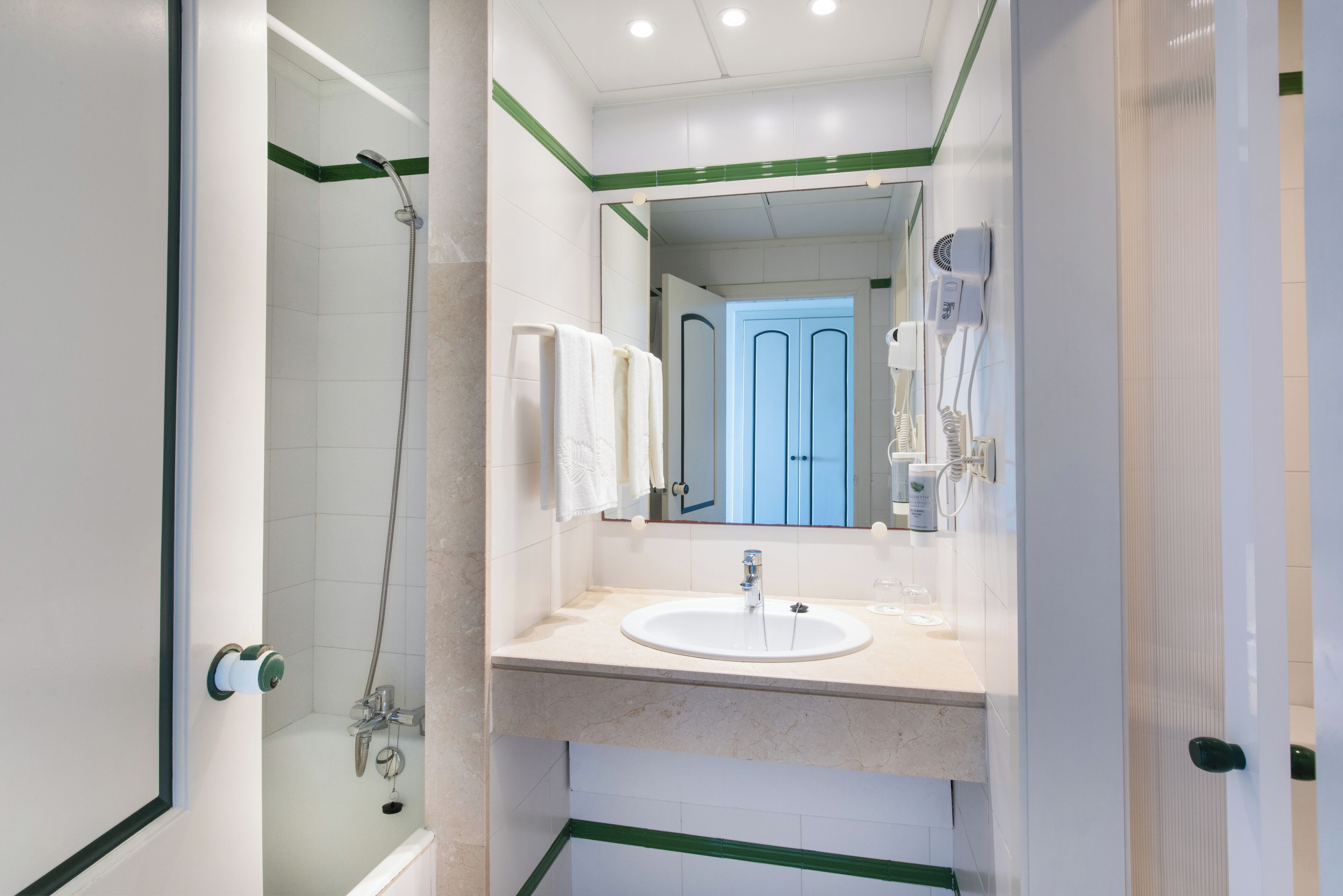 Une salle de bain moderne avec une douche, un lavabo et un miroir.