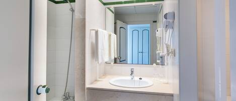 Une salle de bain moderne avec une douche, un lavabo et un miroir.
