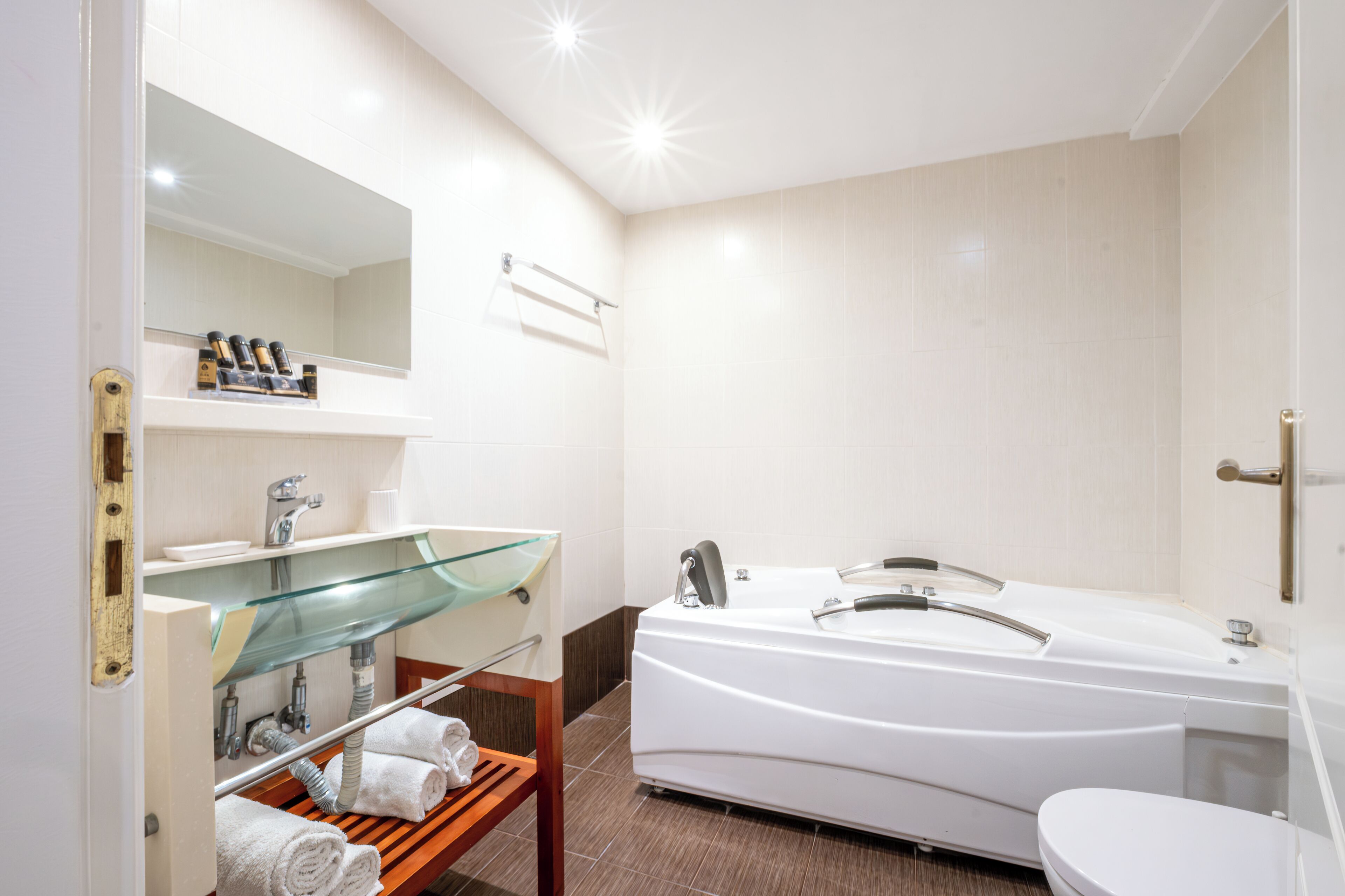A modern bathroom with a glass shower enclosure, a white bathtub, and a toilet.