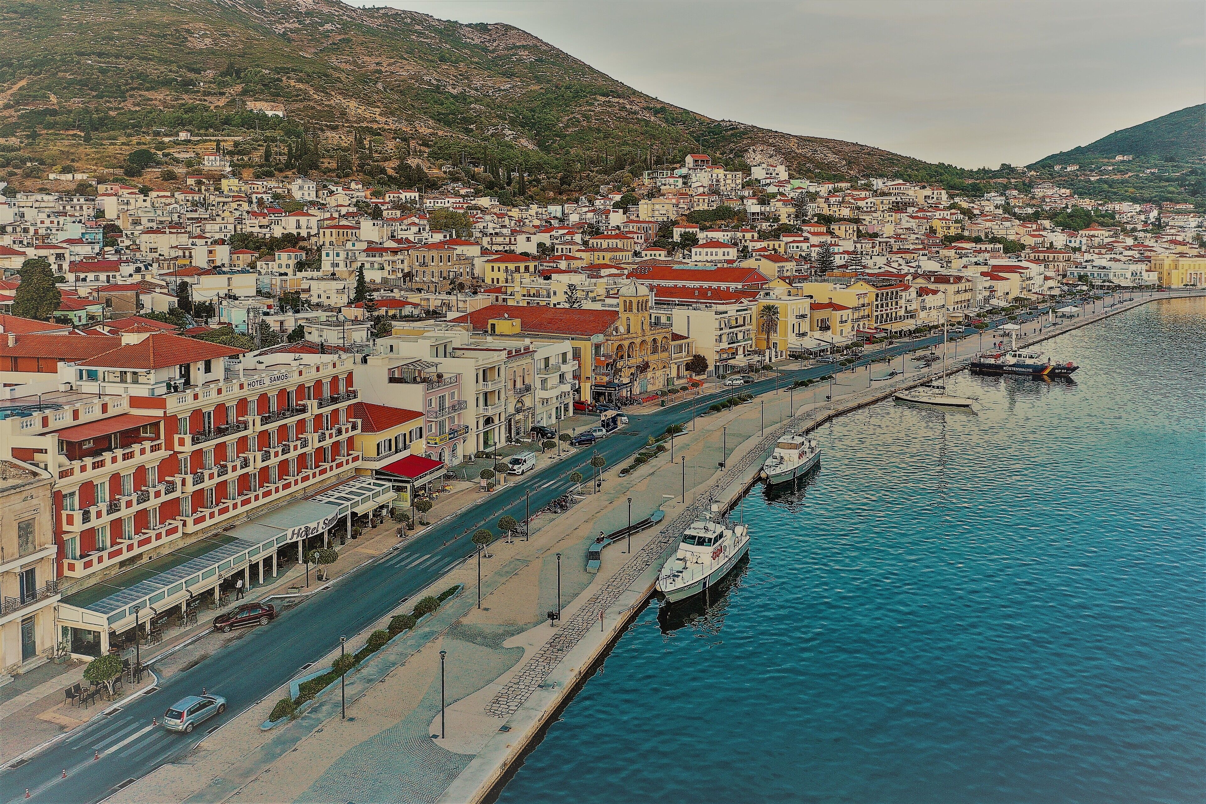 Un pueblo costero con un puerto deportivo, calles estrechas y edificios de techo rojo.